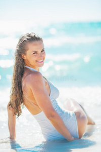 快乐的年轻女人坐在海边