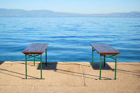 平静的蓝色大海和两张长椅图片