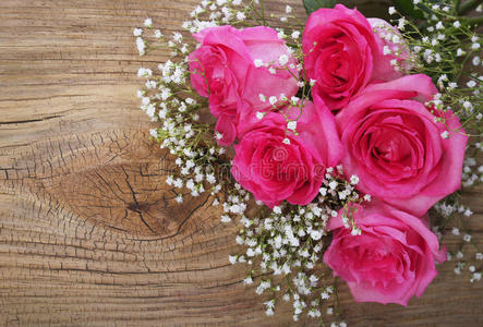 木质背景的粉红色玫瑰和满天星图片