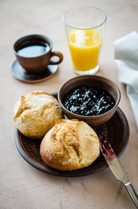 咖啡美式新鲜面包与果酱和果汁。简单的早餐在早上。 乡村风格。