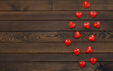 s Day. Red heart shaped candies on a wooden brown background. Th