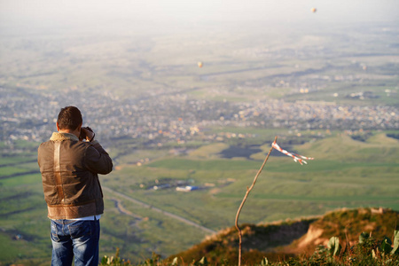 旅行者拍摄山村和热气球图片