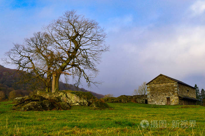 英格兰北部安布里塞德湖地区冬季雾消散时，古老的乡村石农舍。