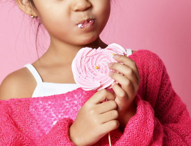 快乐的年轻亚洲小女孩孩子舔吃快乐的大甜棒棒糖粉红色的糖果