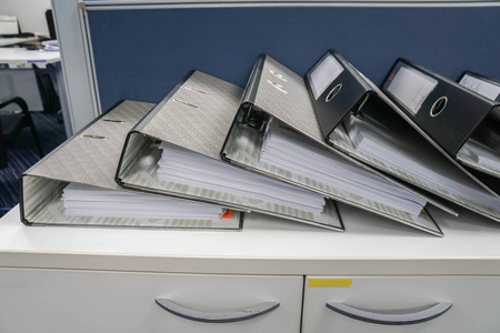 关闭办公室柜上的一堆业务文件夹，以便每月进行审查