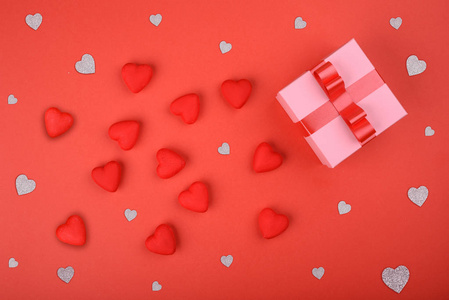 礼品盒。红色背景上的粉红色盒子, 有红色和银色的心。情人节的背景