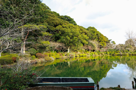 池塘和花园有绿色的水和树在水中的倒影，位于乌米吉戈库或海地狱，有一个池塘与蓝色热水北田日本。