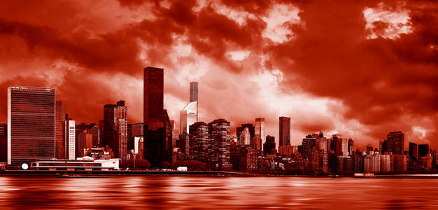 曼哈顿纽约市。 阴天时，市中心天际线穿过东河的全景。 戏剧性的暗红色色调中的图像