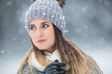 穿着冬装和大雪的年轻漂亮女人的肖像。