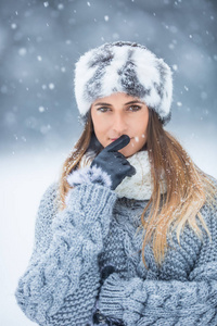 穿着冬装和大雪的年轻漂亮女人的肖像。