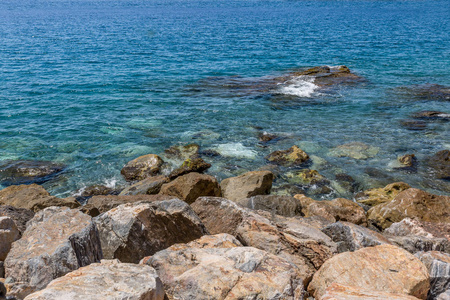 西班牙一片清澈的海水海滩岸边的巨大岩石