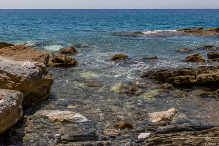 西班牙一片清澈的海水海滩岸边的巨大岩石