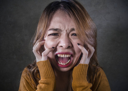 年轻的疯狂绝望和沮丧的亚洲韩国妇女尖叫,恐惧和焦虑,愤怒和痛苦孤立