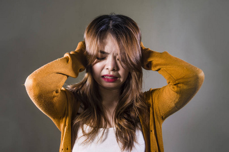 年轻的疯狂绝望悲伤的亚洲女性,在孤独的黑暗背景下,痛苦痛苦表情抑郁