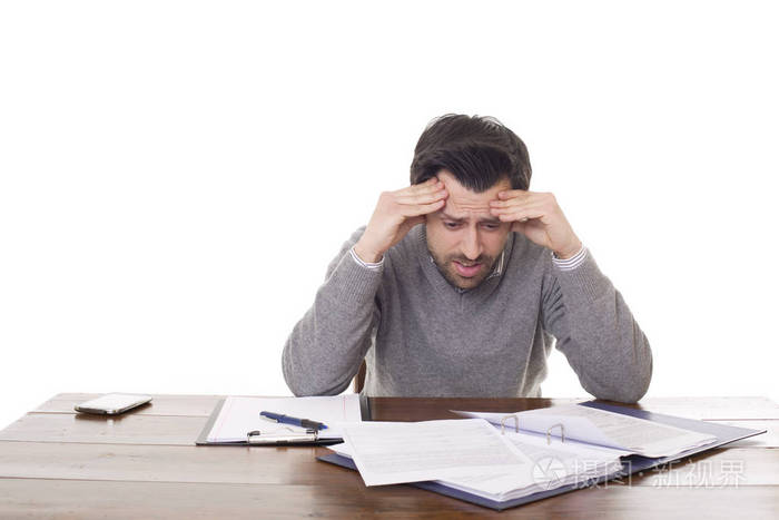 一个担心的男人在桌子上工作被隔离在白色背景上