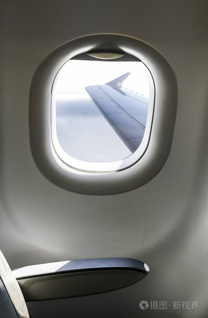飞机内部坐和窗户透过窗户看到的飞机机翼空运概念