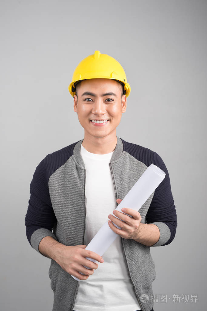 英俊的土木工程师在处理灰色背景的文件