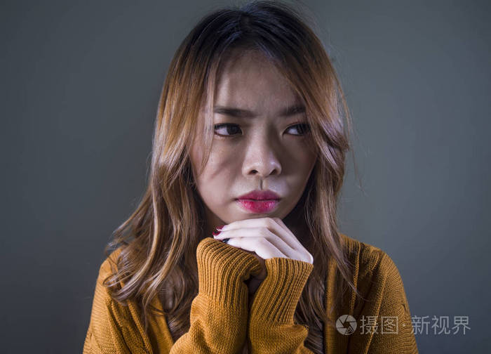 年轻的疯狂,绝望,悲伤的亚洲女性,在孤独的黑暗背景下,痛苦,痛苦,表情