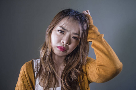 年轻的疯狂绝望悲伤的亚洲女性,在孤独的黑暗背景下,痛苦痛苦表情抑郁