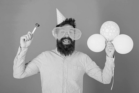 有胡子和胡子的人在快乐的面孔举行空气气球, 蓝色背景。党的理念。时髦的大眼镜庆祝生日。人在党帽子与假日属性庆祝