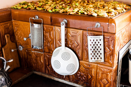 古老的传统烤箱, 瓷砖。炉子上的旧茶壶。厨房采用古老的传统方式。厨房用具在旧烤箱上