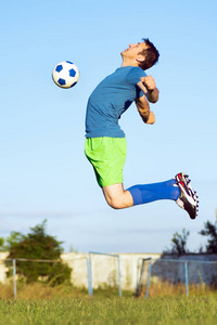 这位足球运动员正在跳跃着用胸部运动动作击球。
