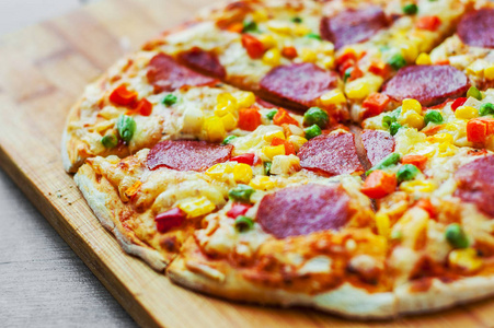 披萨和蔬菜混合马扎雷拉奶酪辣香肠番茄沙拉米。 木制桌子背景意大利披萨