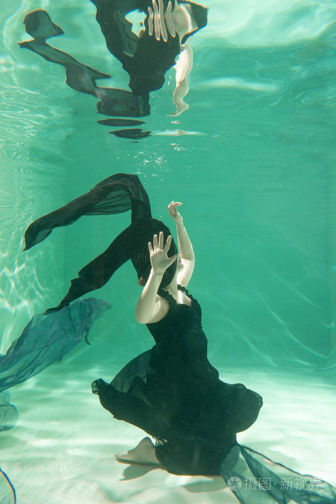 性感苗条的白种人女人独自穿着漂亮的衣服在水里摆姿势