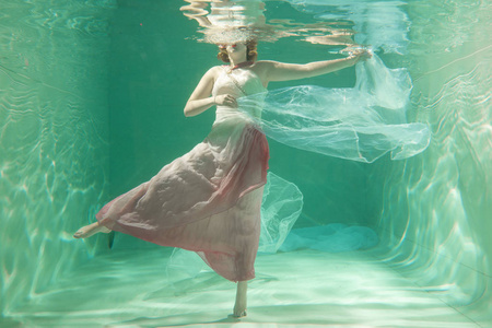 苗条的白种人女人独自穿着漂亮的衣服在水里摆姿势