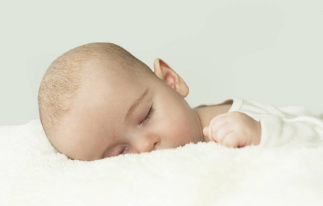 床上一个美丽的熟睡婴儿的特写肖像。健康睡眠概念