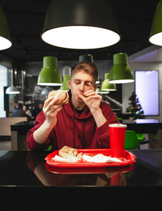 一个年轻有魅力的男人在餐馆吃快餐的画像