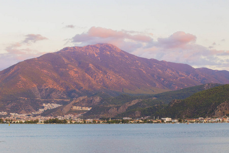 从土耳其Fethiye湾全景。 日出时有云的山景，云上有美丽的粉红色灯光。