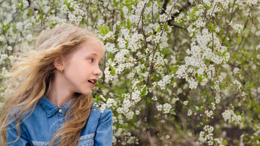 美丽的女孩穿着明亮的蓝色牛仔衬衫在葡萄酒花园。 笑的快乐女孩的肖像。