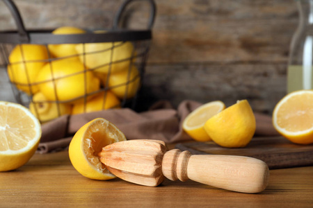 用新鲜柠檬半和木制榨汁机在桌子上组成