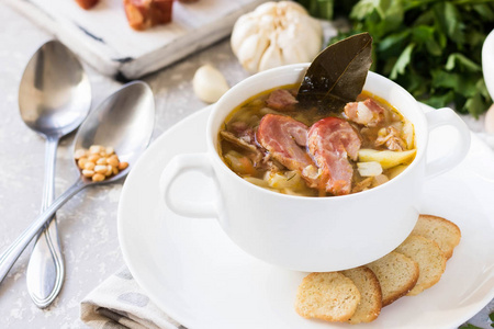 传统自制的厚豆汤，在白色盘子里放熏肉，作为家庭晚餐