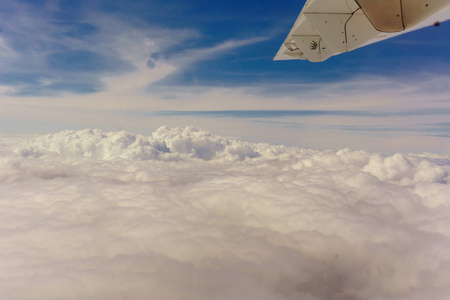 飞机运输概念。 在左翼客机上的视图。在被太阳照亮的厚厚的云层下面。水平视图。