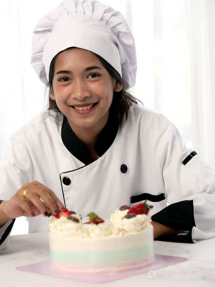 糕点厨师装饰黄油蛋糕与切片草莓生活方式的概念.