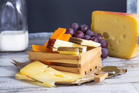 木制桌子上有葡萄的美味奶酪图片