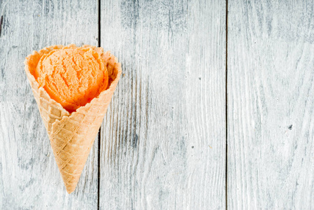 华夫饼冰淇淋筒里的五颜六色的冰淇淋，甜蜜的自制夏日甜点，老式木制背景复制空间俯视图