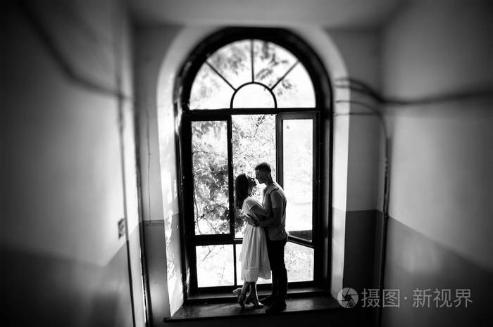 黑白照片情侣在窗边摆姿势