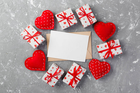 信封邮件与红色的心和礼品盒灰色水泥背景。 情人节贺卡爱情或婚礼问候概念。
