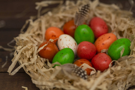 五颜六色的复活节彩蛋在巢的木材背景。 顶部视图，复制空间