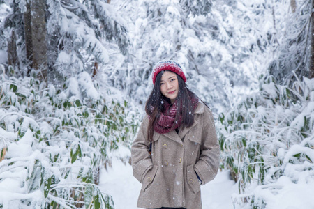 在日本阿尔卑斯山雪天下，戴着红色羊毛帽的女人的肖像感到非常快乐和寒冷。