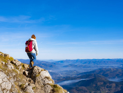 带背包的女旅行者在山上徒步旅行。 登山运动生活方式概念。