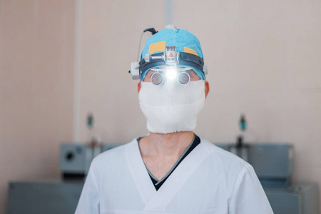 年轻的神经外科医生戴着二元百叶窗的眼镜，在手术室里用光进行显微外科手术。 现代医学。