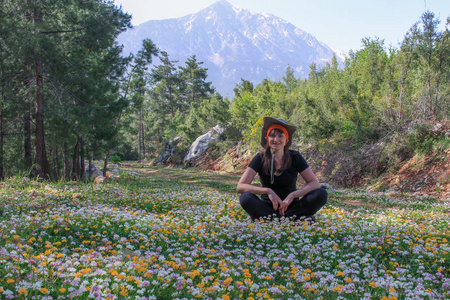 在群山的背景上，五颜六色的花朵盛开的草地。 自然背景