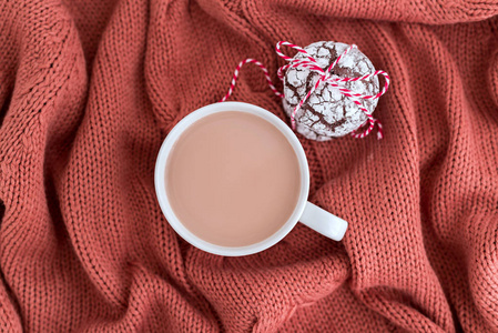 一杯咖啡，牛奶和巧克力饼干在温暖的针织珊瑚毯上。 舒适和喜怒无常的概念。