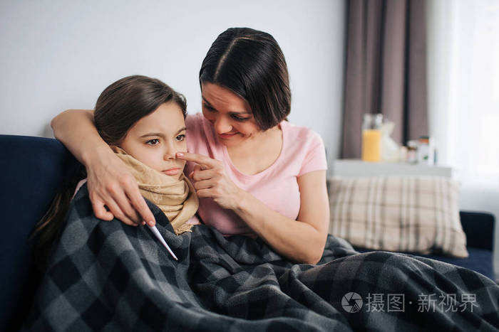 快乐而积极的年轻母亲拥抱和安慰她的孩子.她摸着自己的鼻尖.