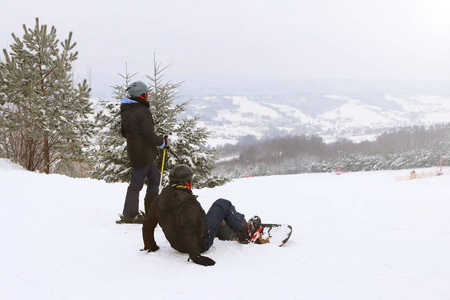 女孩滑雪者和男孩滑雪者站在雪山的背景上上准备回转。 冬季运动的现代体育设备。 山地度假胜地。 露天的体育活动。