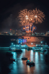 烟花国际五颜六色的芭堤雅海滩城市景观在夜景广告旅游活动假期。 帕塔亚市